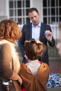 Attorney Rob Mazow distributing safety lights to children for Halloween.