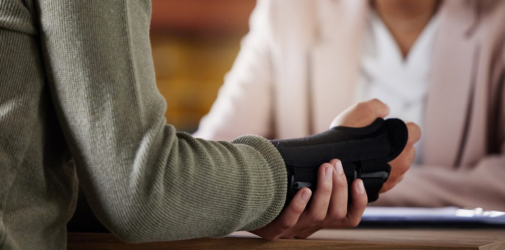 Man with wrist cast speaking to female attorney