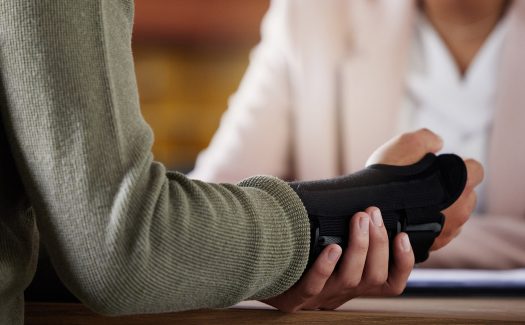 Man with wrist cast speaking to female attorney